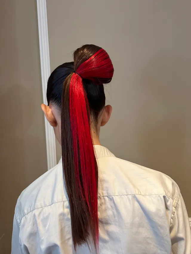 موی بلند حلقه شده در یک طره با رشته هایلایت قرمز رنگ